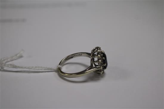 A 9ct white gold, sapphire and diamond oval cluster ring, size L.